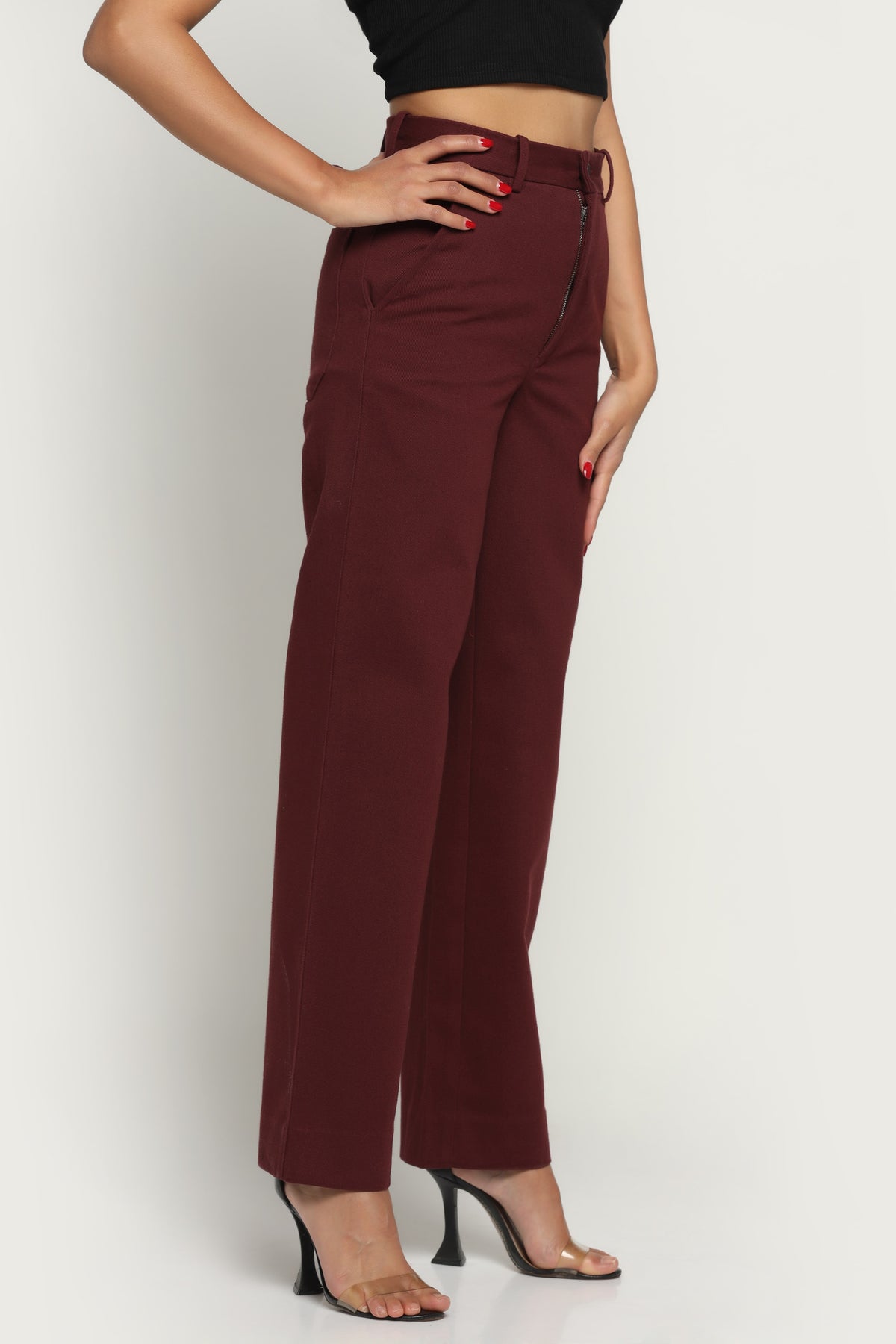 Maroon pants worn by a person on a white background