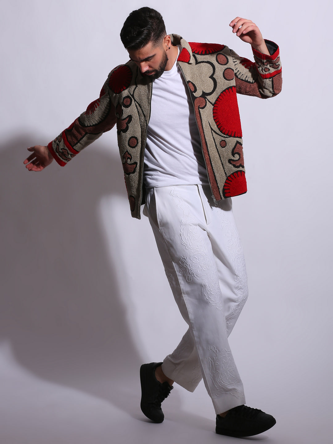 Man wearing a patterned jacket with a plain background