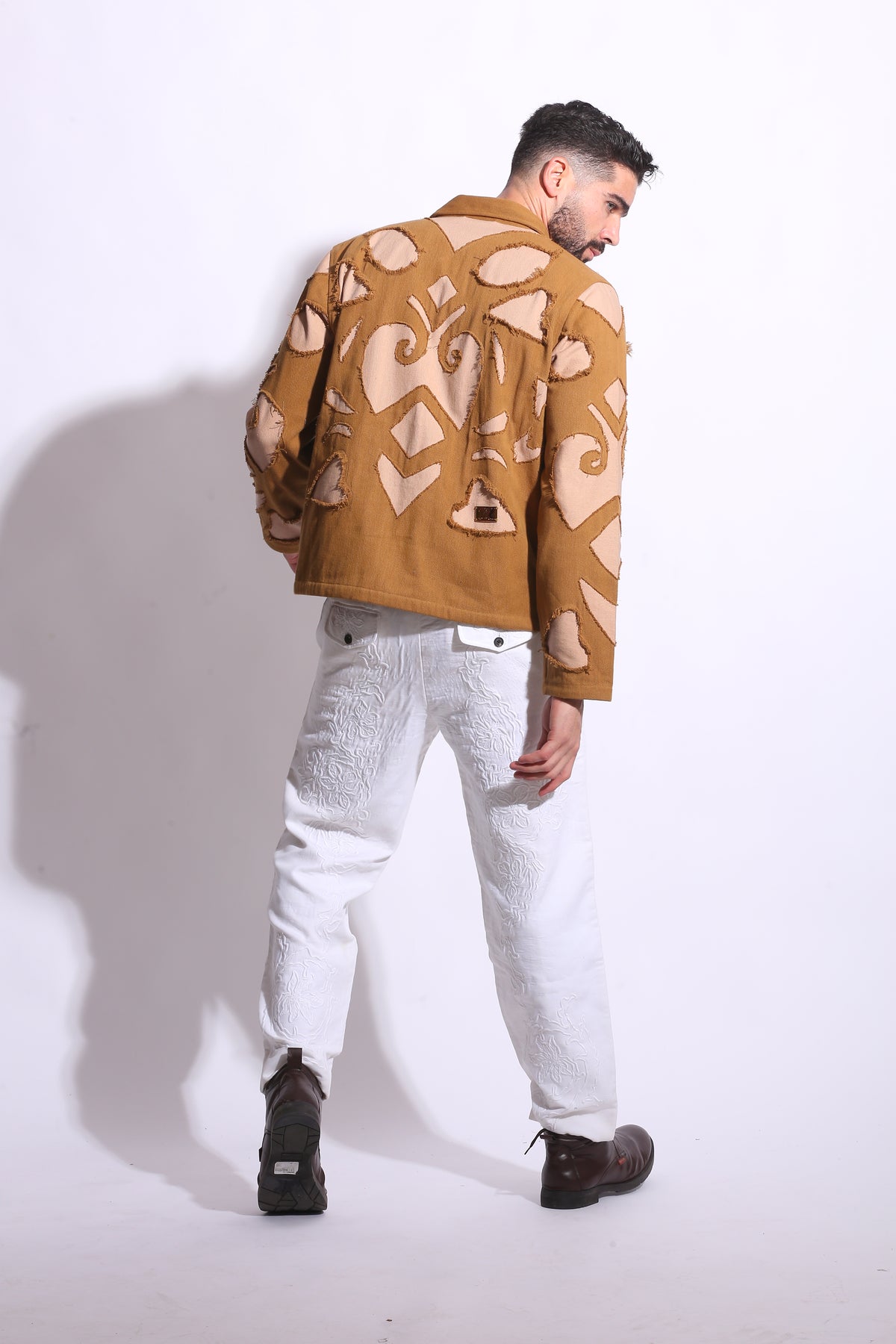 Person wearing a patterned coat on a white background