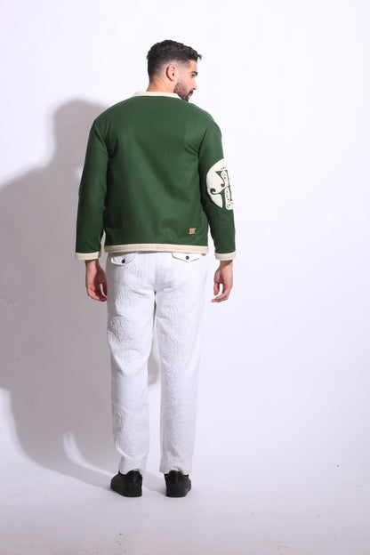 Person wearing a green jacket with white accents on a plain background