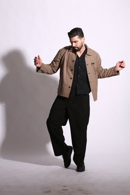 Man in a brown jacket and black pants standing on a white background