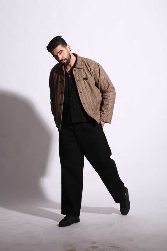 Man wearing a brown coat and black pants on a white background