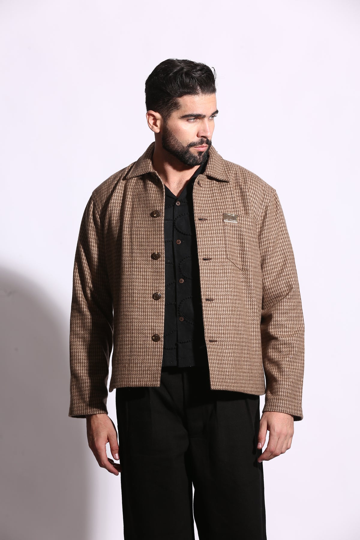 Man wearing a brown checkered suit jacket on a white background