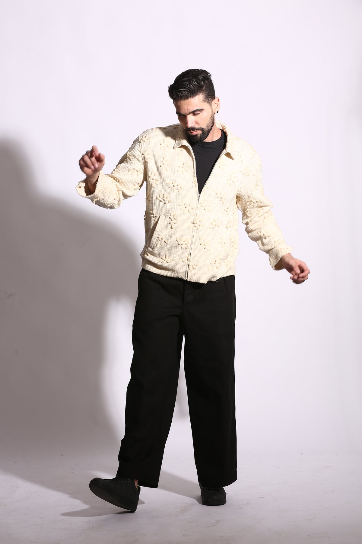 Man lying on a white floor with a neutral expression