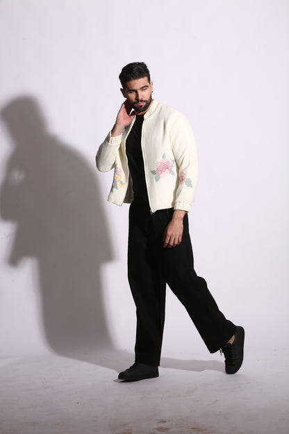 Person wearing a white floral shirt and black pants on a white background