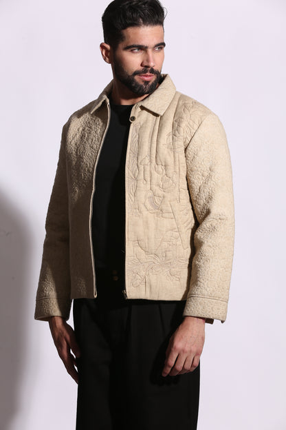 Man wearing a beige embroidered jacket on a white background