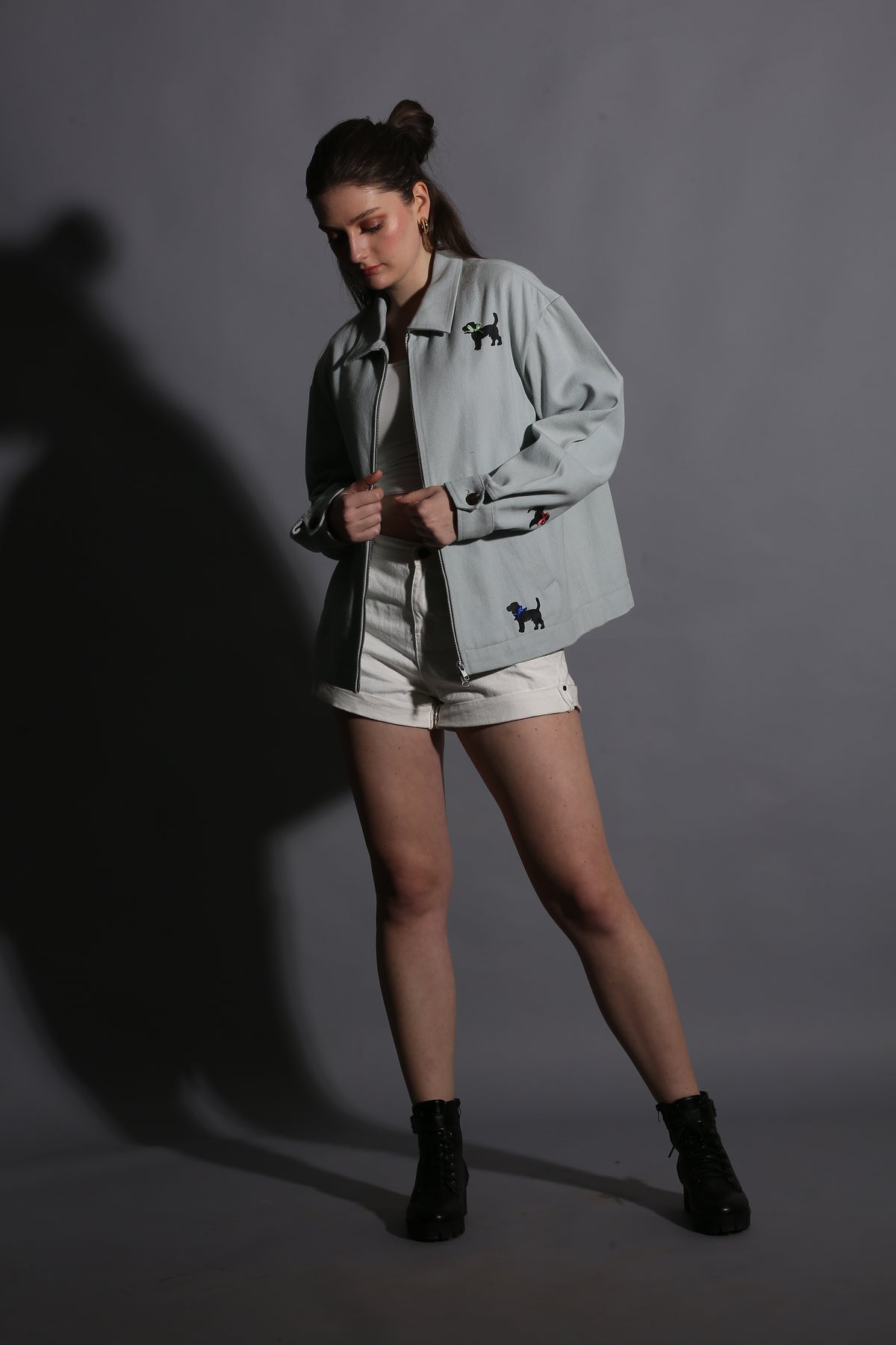 Person wearing a light-colored outfit with black accents on a gray background