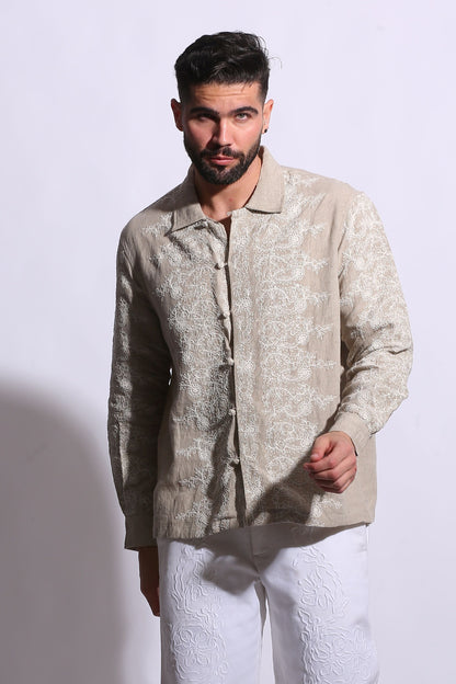 Artisanal linen shirt for men featuring a polo collar and vintage-inspired lattice embroidery in a neutral sand tone.