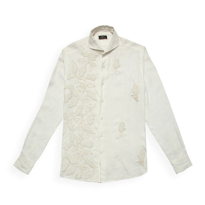 A white linen shirt with intricate hand embroidery in beige tone, displayed against a plain background.